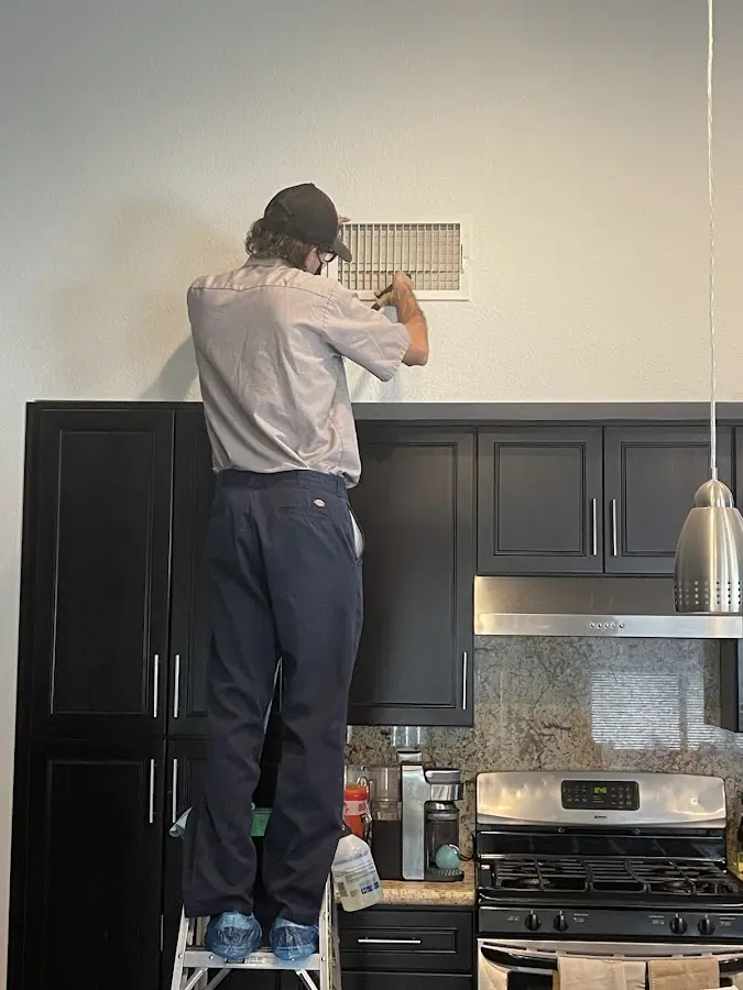 Technician inspecting an air vent during HVAC service in Round Lake Beach